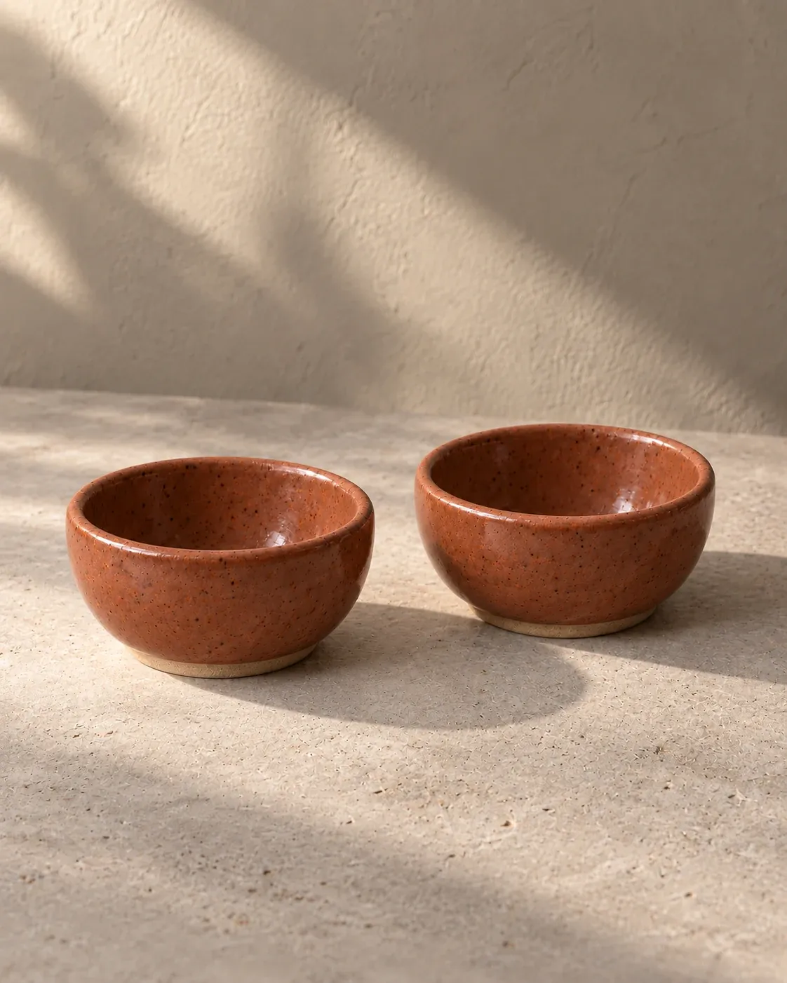 Pinch Pair in Clay, a muted terracotta glaze, exactly two small bowls